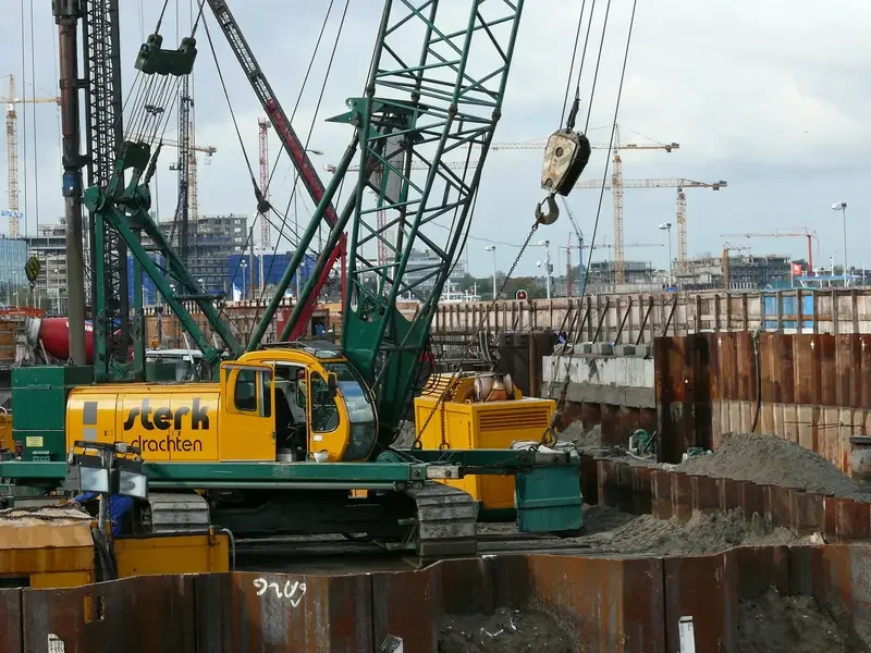Sheet piling and crane operations at urban construction site